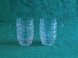 Empty beer glass on a green background. Crystal beer mug. photo