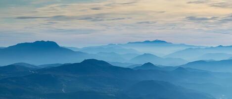 Amazing drone aerial landscape at the Italian Alps in winter and autumn. Morning panorama. Fall sunrise at the alps with moisture and pollution in the air. Silhouette of the mountains and hills photo