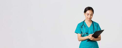 Healthcare workers, preventing virus, quarantine campaign concept. Serious-looking professional female doctor, nurse in scrubs writing down info on clipboard, examine patient, white background photo