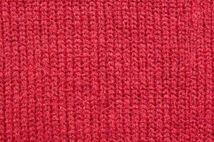 Red knitted wool fabric texture background photo