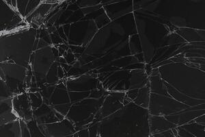Black cracked glass texture background. Crack on the glass. Broken screen. Broken dark phone.  White cracks in glass photo