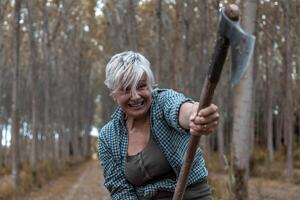 portrait of beautiful mature lumberjack woman with hatchet in action photo