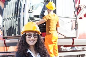 young female engineer posing in junkyard with a worker photo