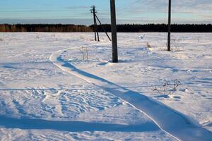 A snow-covered snowmobile track. On a sunny winter day, outdoor activities. photo