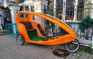 Early in the morning, an empty bicycle rickshaw is parked and waiting for tourists in the old town of Rybinsk, Russia. photo