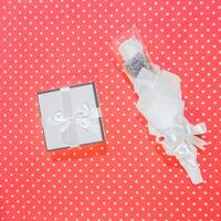 blank gift box with bow on pink background with confetti and confetti. photo