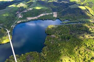 Spectacular aerial view from a drone to a lake and a road between hills. photo