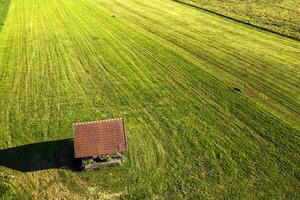 aéreo ver de el hermosa paisaje de un antiguo de madera casa en un verde campo foto