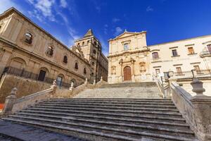 Iglesia de Santo francisco de Asís, un icónico edificio en el histórico centrar de noto, un pintoresco pueblo en Sicilia, Italia. a el izquierda, es el edificio de seminario vescovil. foto