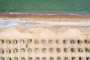 Aerial view of a beach with wooden umbrellas, and calm sea. photo