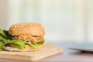 un delicioso hamburguesa comida con queso, lechuga, tomate, y carne de vaca en el trabajo mesa foto