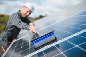 Worker cleaning solar panels after installation outdoors photo