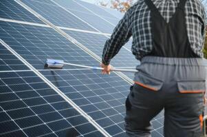 technician operating and cleaning solar panels at generating power of solar power plant photo