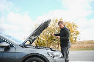 a man feel stress because his car is broken down photo