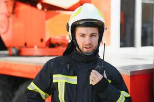 Photo of fireman with gas mask and helmet near fire engine