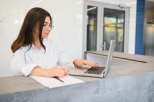 Portrait of receptionist at desk in lobby photo