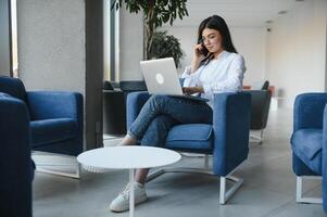 hermosa joven persona de libre dedicación mujer utilizando ordenador portátil computadora sentado a café mesa. contento sonriente niña trabajando en línea o estudiando y aprendizaje mientras utilizando cuaderno. Lanza libre trabajar, negocio personas concepto. foto