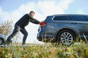 hombre emprendedor un roto coche abajo el rock la carretera foto