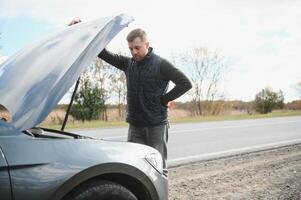 hombre comprobación su rompió abajo coche foto