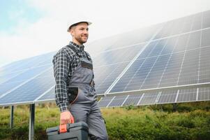 Expert is inspecting quality of a solar batterys. Worker in uniform and helmet with equipment. Ecology power conservation concept. photo