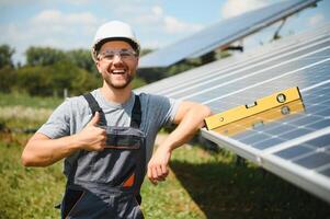 Male engineer in protective helmet installing solar photovoltaic panel system. Alternative energy ecological concept. photo