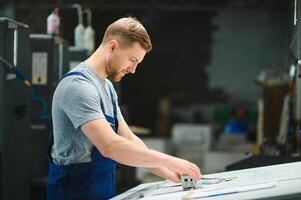 Man working in printing house with paper and paints photo