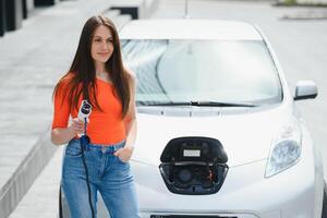 mujer es cargando alquiler eléctrico coche foto