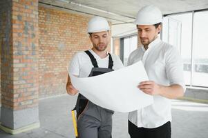 construcción concepto de ingeniero y arquitecto trabajando a construcción sitio con azul impresión. foto