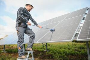 Worker cleaning solar panels after installation outdoors photo