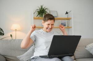 Technology, people and communication concept - Happy senior woman with tablet pc computer having video chat at home. Modern middle-aged 50s grandmother sit relax on couch in living room using laptop. photo