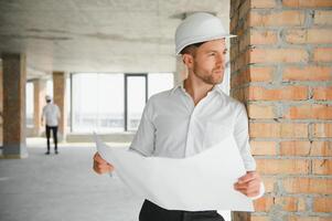 cerca arriba ingenieros trabajando en un edificio sitio participación un planos.ingenieria y arquitectura concepto foto