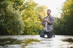 Fisherman hunting trouts in mountain river. Fishing net detail. photo