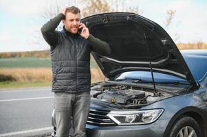 car broke down on the road, a man calls the emergency service, a tow truck. photo