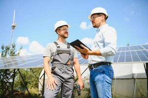 Businessman and worker near solar energy batteries. Two men making deal. photo