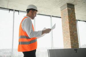 cerca arriba ingenieros trabajando en un edificio sitio participación un planos.ingenieria y arquitectura concepto foto