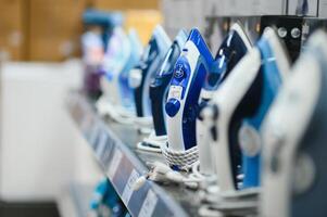 Image of assortment of different irons at household appliances shop photo