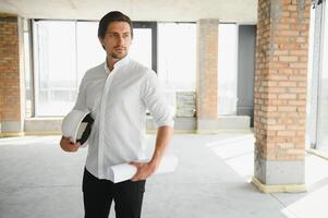 retrato de hombre arquitecto a edificio sitio. confidente construcción gerente vistiendo casco de seguridad. exitoso maduro civil ingeniero a construcción sitio con Copiar espacio. foto