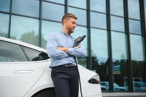 un empresario cargos un eléctrico coche. foto