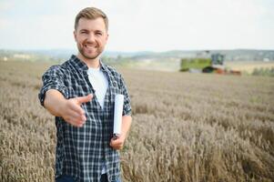 joven granjero en trigo campo durante cosecha en verano foto