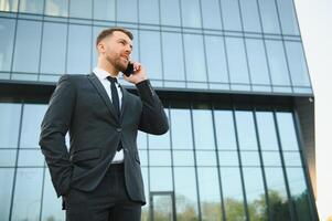 Businessman using smartphone in covered walkway. photo