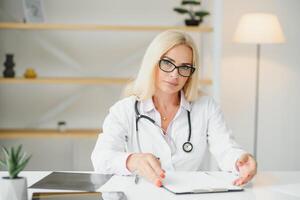 Doctora de mediana edad escribiendo receta foto