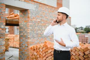 Engineering Consulting People on construction site holding blueprint in his hand. Building inspector. Construction site check drawing and business workflow of new building. photo