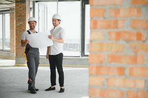 Male Architect Giving Instructions To His Foreman At Construction Site. photo