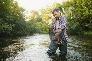 trout being caught in fishing net. photo