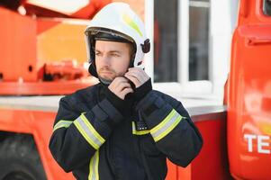 Photo of fireman with gas mask and helmet near fire engine