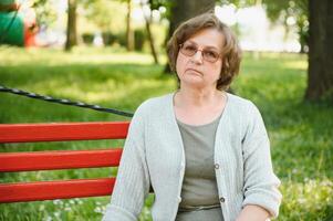 Portrait of a happy Senior woman in summer park photo