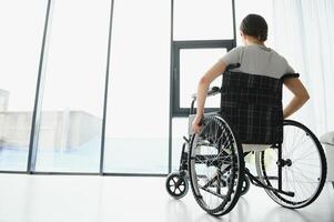 Young woman in wheelchair at home in living room. photo