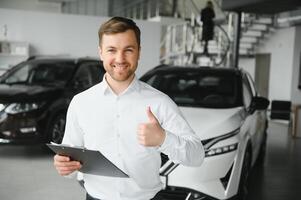 retrato de mente abierta profesional vendedor en carros sala de exposición, caucásico hombre en blanco formal camisa soportes siguiente a lujoso coche y mira a cámara foto