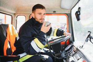 Firefighter using portable radio set in fire truck, space for text photo