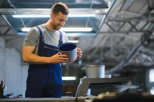 Man working in printing house with paper and paints photo